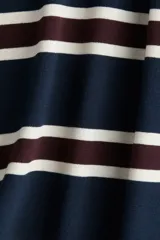 Remera de manga tres cuartos con corte holgado, confeccionada en punto de algodón pesado. Presenta un patrón de rayas horizontales en azul marino, blanco y granate, con cuello redondo ribeteado acanalado y hombros caídos.