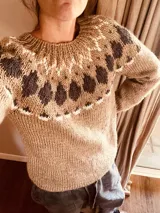 Sweater tejido a mano con patrón de hojas en tonos marrón, beige y blanco.