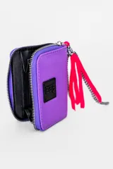 Billetera verde esmeralda con cierre de cremallera y detalle de borla roja y negra.