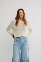 Sweater de punto grueso color beige, de calce amplio y largo corto, con escote redondo, mangas caídas y terminaciones acanaladas en tejido abierto.