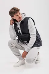 Chaleco puffer color gris topo, con cuello alto y cierre frontal.