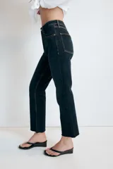 Jeans de tiro alto con cinco bolsillos, diseño cropped flare y bajo sin costuras. Cuenta con cierre frontal de cremallera y botón metálico.