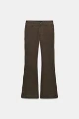 Pantalón flare de tiro medio confeccionado en lino color marrón. Cuenta con cintura con trabillas, bolsillos delanteros, perneras de corte evasé y cierre frontal con cremallera y botón.