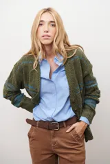 Sacon de tejido de punto grueso con diseño de ochos y rayas horizontales en contraste. Presenta cuello en V, cierre frontal con botones oscuros y mangas largas con puños acanalados.