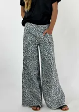 Pantalón jean de corte ancho con estampado animal print en tonos beige y gris.