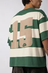 Remera de tejido de punto con diseño de rayas horizontales anchas en color bordó y crema, de corte oversize y cuello redondo.