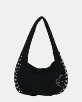 Bolso de hombro tipo hobo color negro, con acabado de gamuza o material similar. Decorado con tachas metálicas redondas plateadas a lo largo del borde inferior y en un dije colgante con forma de corazón.
