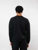 Buzo de felpa color crema, con cuello redondo, manga larga tipo raglán y puños y dobladillo acanalados. Incluye una etiqueta con el logo de Umbro en la parte delantera.