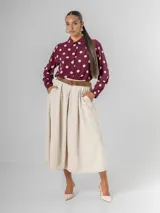 Falda midi de corte clásico confeccionada en corderoy, con cintura elastizada, diseño de tablas y bolsillos laterales. Incluye un cinturón desmontable en color marrón.