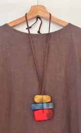 Collar con cinta de gamuza marrón regulable y dije con tres piezas rectangulares de acrílico en colores amarillo, azul y rojo.