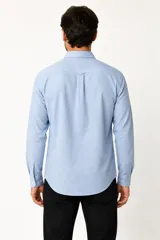 Camisa de viscosa color negro, de manga larga, con cuello camisero y cierre frontal de botones.