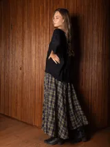 Pollera larga de corte amplio y voluminoso, con estampado de cuadros escoceses en tonos azul marino y amarillo. Presenta cintura elástica y bolsillos laterales.