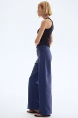 Pantalón de tiro alto confeccionado en lona de algodón, con diseño de pierna recta, raya marcada en el frente y la espalda, cierre con botones metálicos y bolsillos de parche en la parte posterior.