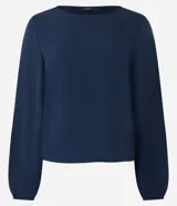 Blusa de manga larga confeccionada en crepé color azul marino, con escote redondo y puños elásticos.