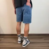 Bermuda de jean estilo jogger con efecto desgastado, roturas frontales y ruedo desflecado.