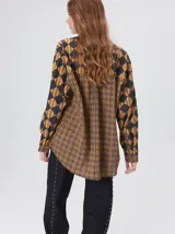 Camisa de manga larga con diseño estampado de rombos en tonos tierra, confeccionada en viscosa. Presenta cuello clásico, cierre frontal con botones, un bolsillo cuadrado en el pecho con logo bordado y puños a juego.