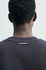 Remera relaxed fit confeccionada en tejido compacto de algodón con elasticidad, cuello redondo y manga corta.
