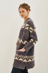 Tapado tipo cárdigan de tejido de punto con diseño geométrico en tonos azul, gris y crudo. Presenta un corte holgado, mangas largas y bolsillos laterales frontales.