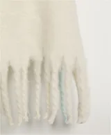 Bufanda manta de tejido suave y peluche, color celeste claro, con flecos largos en los extremos de color beige.