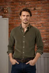 Camisa azul marino de pana, de corte slim fit, con cuello clásico, botones delanteros claros y detalle de ave bordada en el pecho.