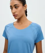 Remera deportiva de microfibra color blanco, con cuello redondo, mangas cortas y paneles laterales con textura perforada para mayor ventilación.