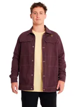 Chaqueta de gabardina color bordó, con cierre frontal de botones metálicos, bolsillos superiores con solapa y bolsillos laterales. Presenta costuras a la vista y etiqueta de la marca en el pecho.