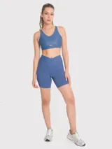 Calza biker de tiro alto con pretina en V, confeccionada en tejido técnico elástico de color azul. Presenta un diseño ajustado con bandas de silicona internas para mayor sujeción.
