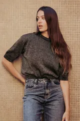 Sweater de punto color tostado con hilos metalizados, de corte recto, escote redondo y mangas cortas con puño ajustado.