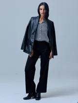 Blazer de eco cuero negro con corte oversized, cuello con solapa, cierre frontal con botones y bolsillos delanteros aplicados.