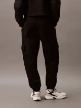 Pantalón de chándal negro de corte holgado con bolsillos cargo, cintura elástica y bajos elásticos. Confeccionado en felpa de mezcla de algodón.