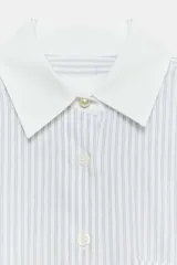 Camisa de algodón con estampado de rayas verticales, cuello solapa y puños en color blanco a contraste. Presenta cierre frontal con botones, bolsillo de plastrón en el delantero y bajo asimétrico.