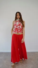 Top halter de seda blanco con estampado floral en rojo, con cuello alto y lazo en la espalda.