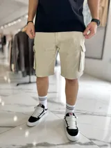 Bermuda cargo de jean color beige, con bolsillos laterales con solapa en las piernas y corte holgado.