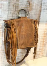 Cartera de cuero color marrón con diseño boho, decorada con flecos largos en los laterales. Cuenta con asas circulares metálicas y una correa larga ajustable y extraíble para usar como bandolera.