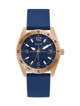 Reloj analógico Guess modelo North con caja de acero en tono oro rosa, esfera azul con textura concéntrica y malla de silicona azul. Presenta bisel con indicadores de dirección y números arábigos en la esfera.
