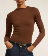 Blusa de manga larga con diseño ajustado, confeccionada en tejido acanalado de viscosa con elastano. Presenta cuello redondo y sisas raglán.