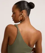 Vestido midi de color verde militar, confeccionado en tejido rib de poliamida. Presenta diseño de un solo hombro, fruncidos laterales a lo largo del cuerpo y tajo lateral en el bajo.