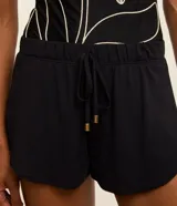 Short corto blanco de crepé con cintura elástica, cordón ajustable con punteras doradas y ruedo redondeado, diseñado como salida de playa por Bossa Nossa.