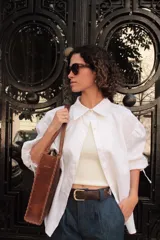 Camisa blanca de lino con cuello clásico, mangas abullonadas 3/4 y cierre frontal con botones.