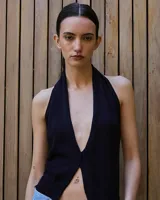 Top tejido de punto color negro, con escote halter pronunciado y espalda descubierta.