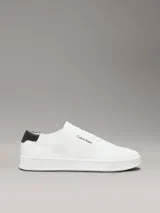 Zapatillas de perfil bajo Calvin Klein confeccionadas en tejido de punto transpirable color blanco. Presentan un diseño minimalista con puntera revestida, suela de goma blanca y detalle de trabilla trasera en piel color negro con el logo de la marca en el lateral y la mediasuela.