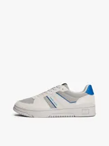 Zapatillas Tommy Jeans de corte bajo, confeccionadas en ante con paneles de malla y cuero sintético. Presentan un diseño en tonos gris y blanco con detalles en azul vibrante, cordones moteados y suela cupsole de goma con logo en bajo relieve.