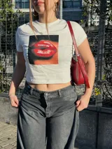 Remera negra corta con estampado frontal de labios rojos y la frase "Don't be jealous.", manga corta y cuello redondo.