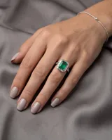 Anillo de plata 925 con piedra central rectangular verde de raíz de esmeralda, rodeada de circonias.