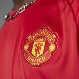 Camiseta de fútbol Adidas del Manchester United, modelo Home 24/25. Diseño rojo con detalles blancos en cuello y mangas. Incluye logo de Adidas, escudo del club y sponsor Snapdragon en el frente.