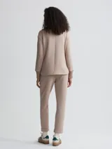 Campera color beige de corte holgado, con cierre frontal, cuello alto y bolsillos de parche grandes.