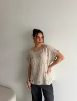 Blusa de manga corta color beige con delicados bordados florales dispersos, de corte holgado y escote redondo.
