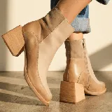 Bota corta de cuero vacuno con diseño bicolor en tonos marrones, combinando texturas lisas y con relieve tipo reptil. Presenta un taco cuadrado de madera forrado en cuero y punta cuadrada.