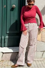 Remera de algodón color bordó, con mangas largas estilo oxford que presentan un diseño acampanado en los puños y escote bote.