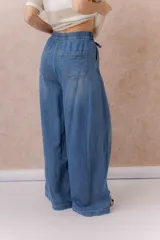 Jean de calce amplio y relajado, color azul, con pierna extra ancha y caída fluida. Diseño de tiro alto con pinzas delanteras y lazo regulable en la cintura. Cuenta con bolsillos laterales y traseros.